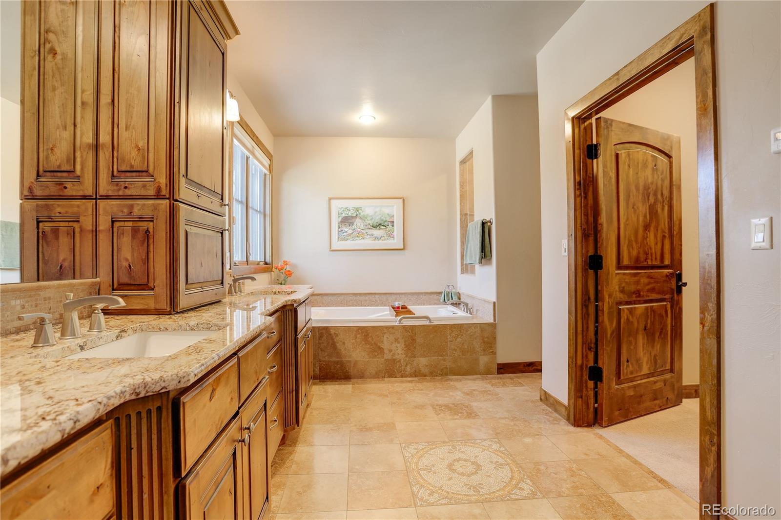 92 Whiskey Jay Hill Road Evergreen, CO 80439 - Photo 27 of 45 a bathroom with a granite countertop tub sink and mirror