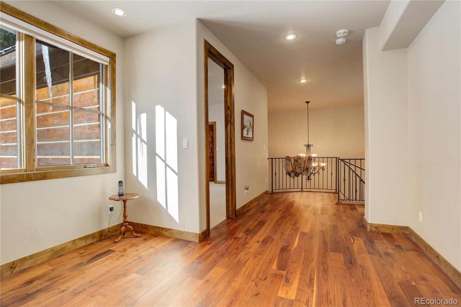 92 Whiskey Jay Hill Road Evergreen, CO 80439 - Photo 29 of 45 a view of empty room with wooden floor and fan