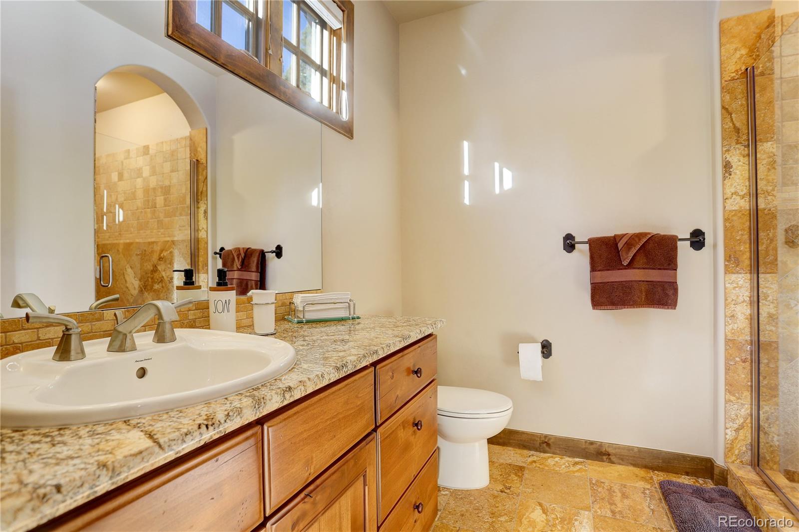 92 Whiskey Jay Hill Road Evergreen, CO 80439 - Photo 31 of 45 a bathroom with a granite countertop sink and a mirror