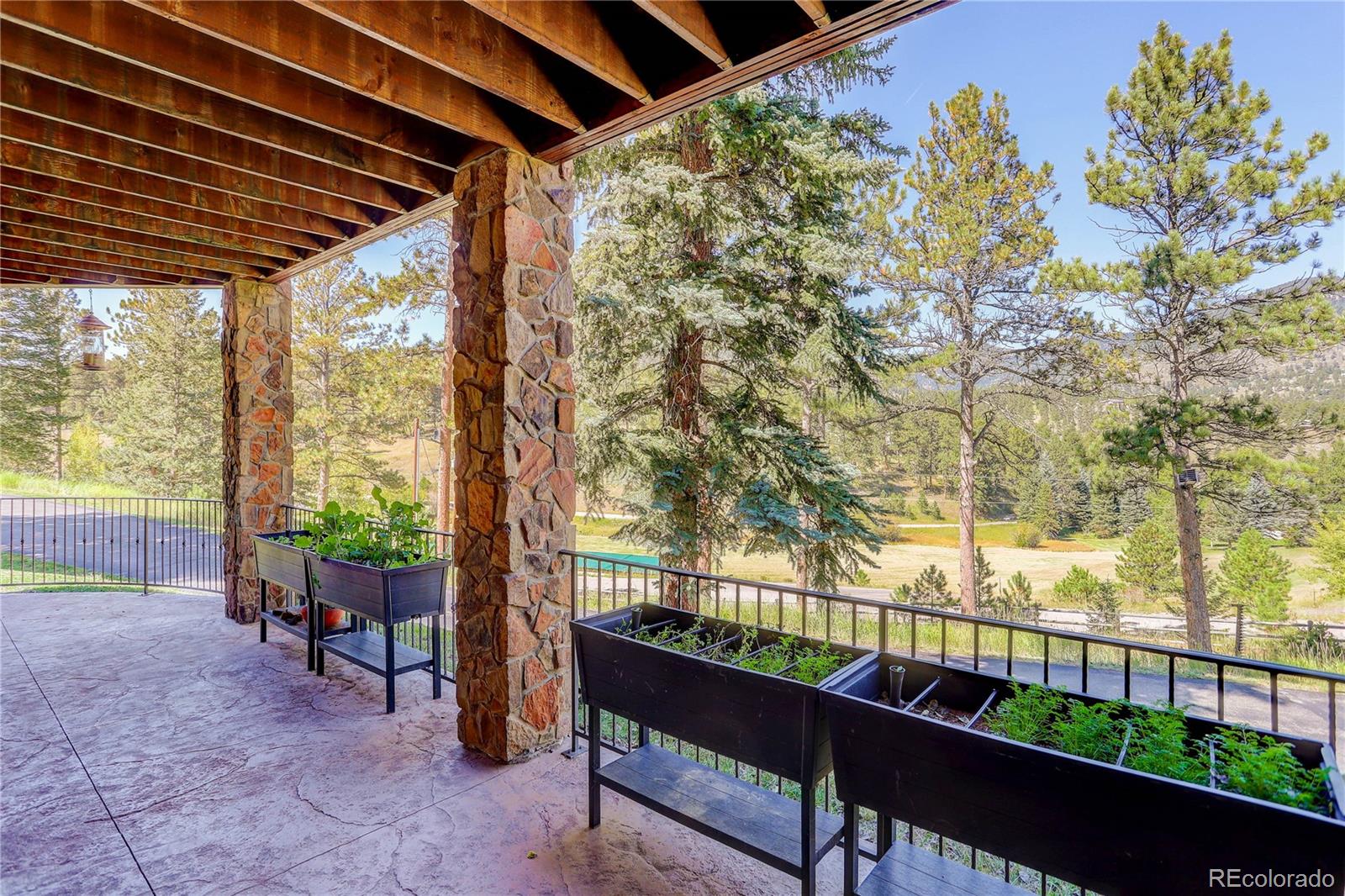 92 Whiskey Jay Hill Road Evergreen, CO 80439 - Photo 39 of 45 a porch with a bench next to a yard