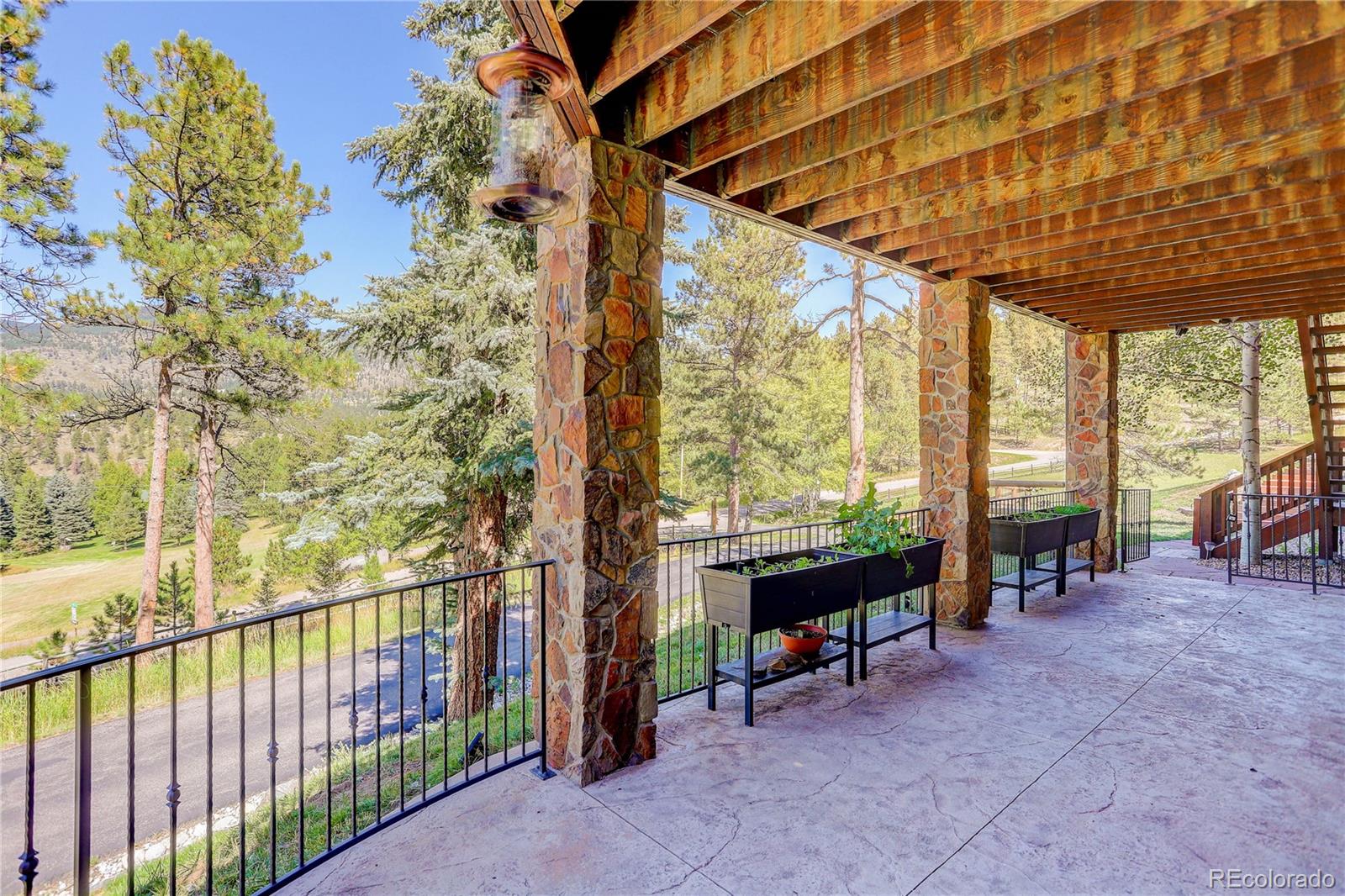 92 Whiskey Jay Hill Road Evergreen, CO 80439 - Photo 40 of 45 a view of a porch with furniture and floor to ceiling window