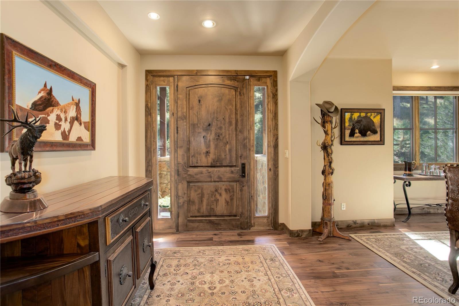 92 Whiskey Jay Hill Road Evergreen, CO 80439 - Photo 6 of 45 a view of a hallway with wooden floor and furniture