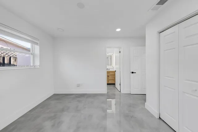 a bathroom with a granite countertop sink a toilet a mirror and shower