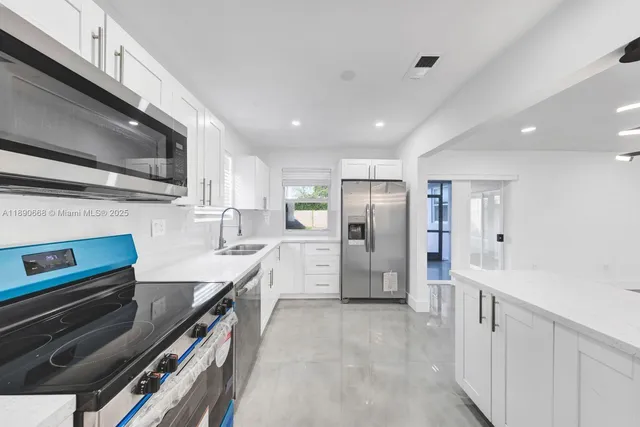 a view of a kitchen with a sink and refrigerator