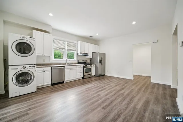 a view of a kitchen with a sink a microwave and cabinets