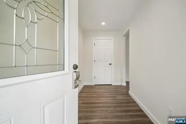a view of a hallway with wooden floor and entryway
