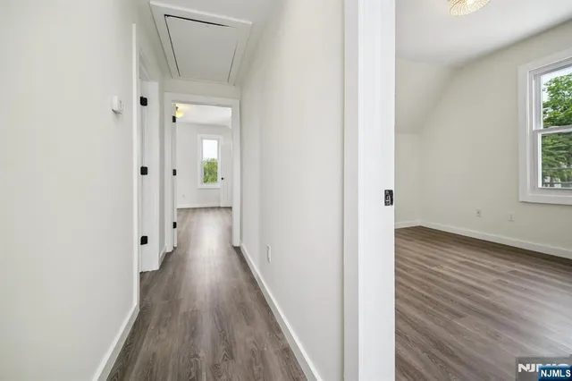 a view of a hallway with wooden floor