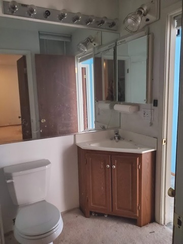 324 Inverrary Lane, Unit D Deerfield, IL 60015 - Photo 28 of 32 a bathroom with a sink a toilet and mirror
