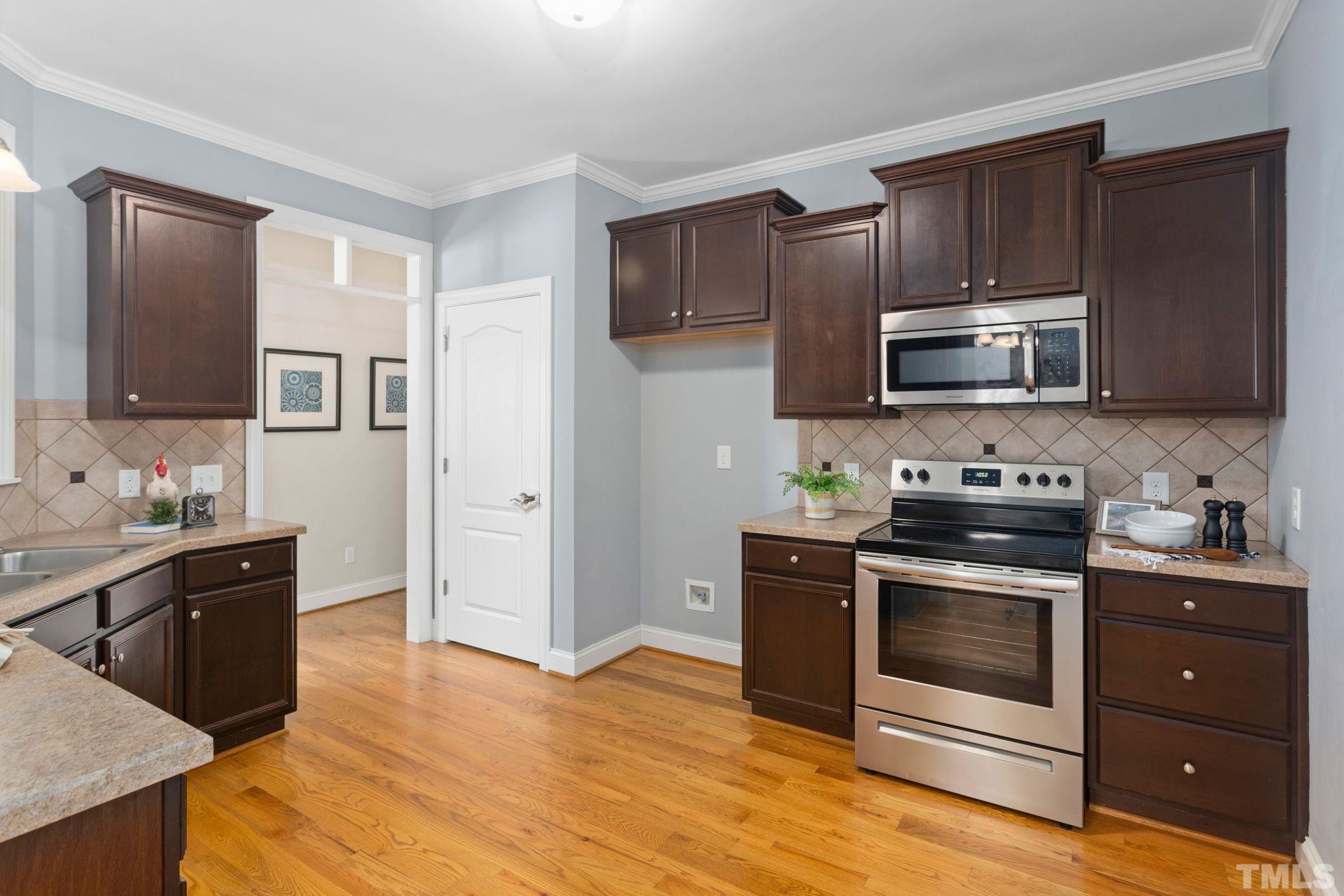 1425 Silver Farm Road Raleigh, NC 27603 - Photo 8 of 23 a kitchen with granite countertop wooden cabinets and stainless steel appliances