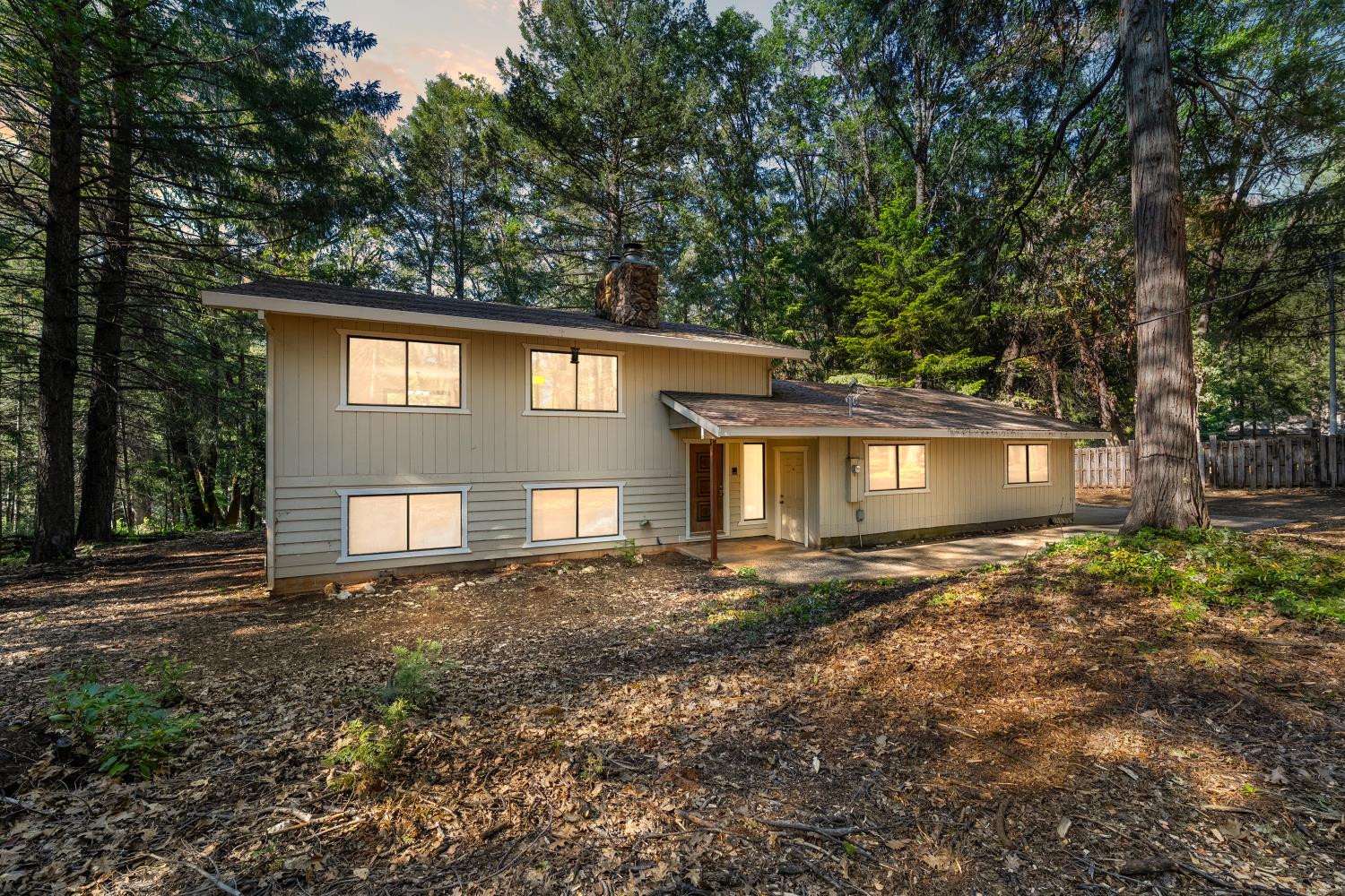 a front view of a house with a yard and trees