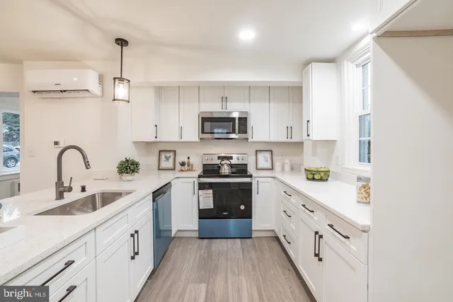 a kitchen with cabinets stainless steel appliances a sink and a stove
