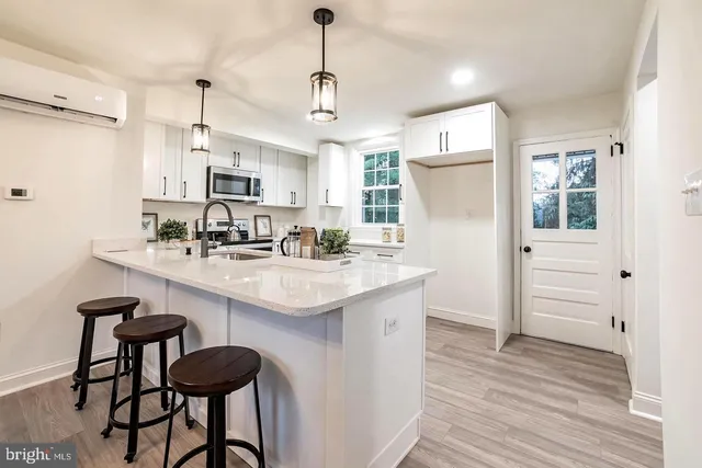 a kitchen with kitchen island granite countertop a sink cabinets and wooden floor