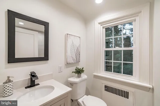 a bathroom with a sink a toilet and a window