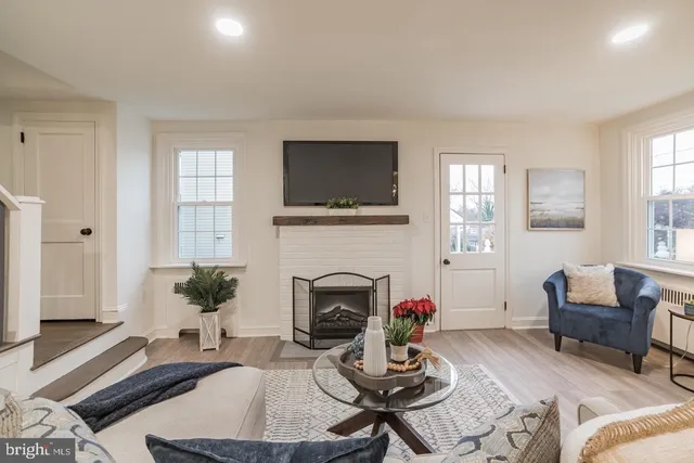 a living room with furniture a fireplace and a window