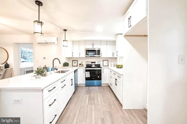 a large kitchen with a stove top oven a sink a dining table and chairs