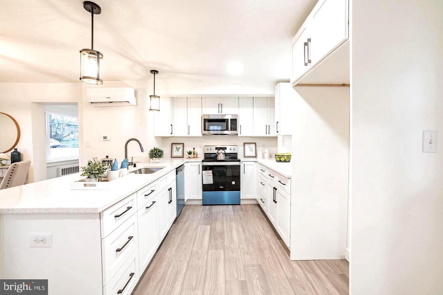 115 Beech Road Wallingford, PA 19086 - Photo 10 of 29 a large kitchen with a stove top oven a sink a dining table and chairs