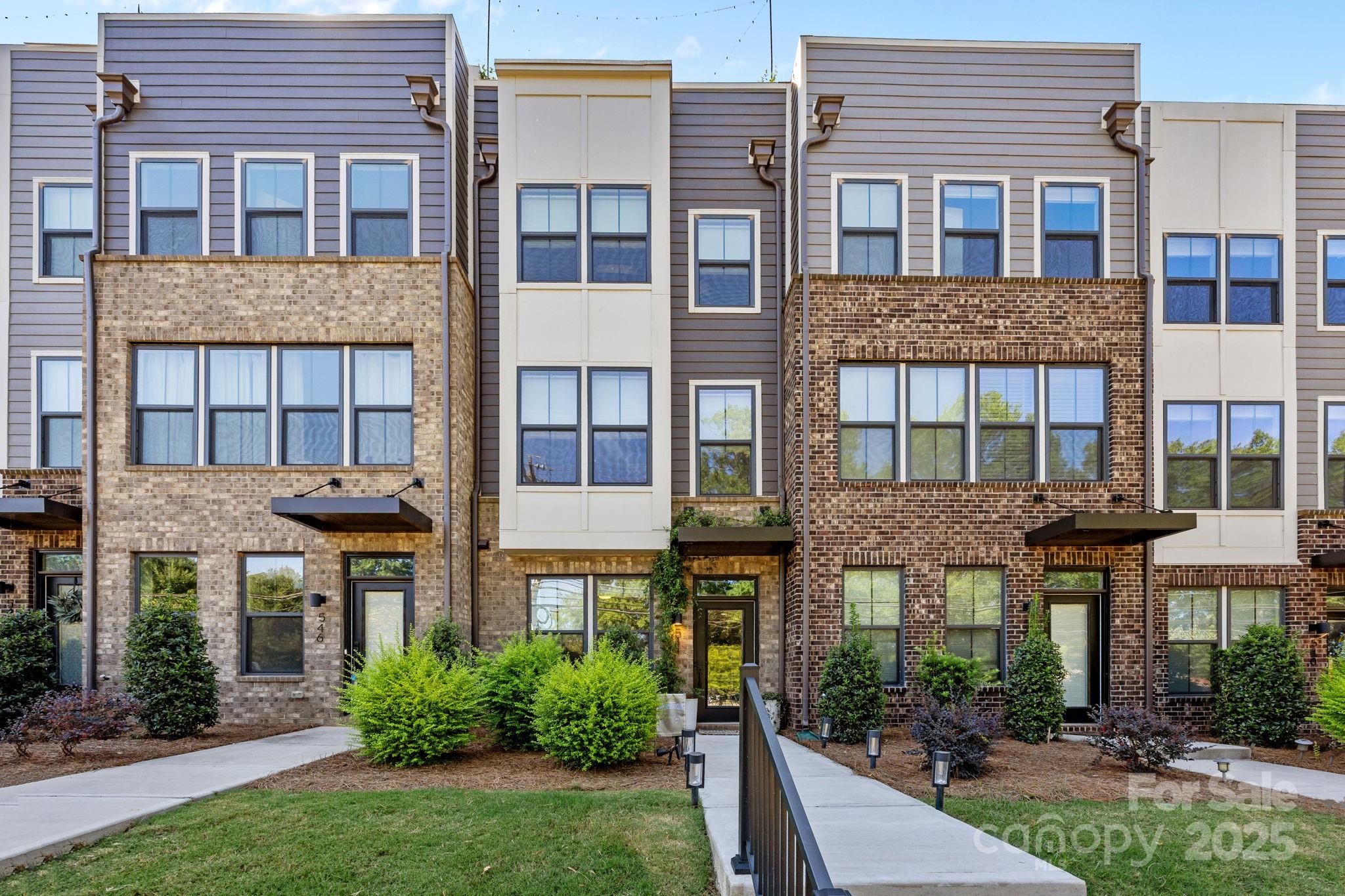 a front view of a building with plants and entryway