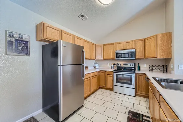 a kitchen with stainless steel appliances granite countertop a refrigerator stove and sink