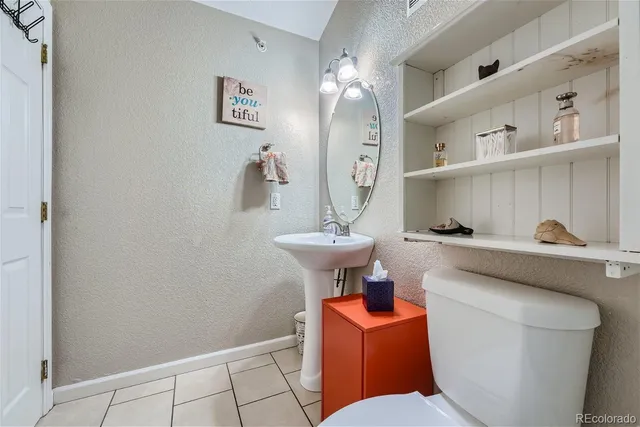 a bathroom with a toilet a sink and mirror