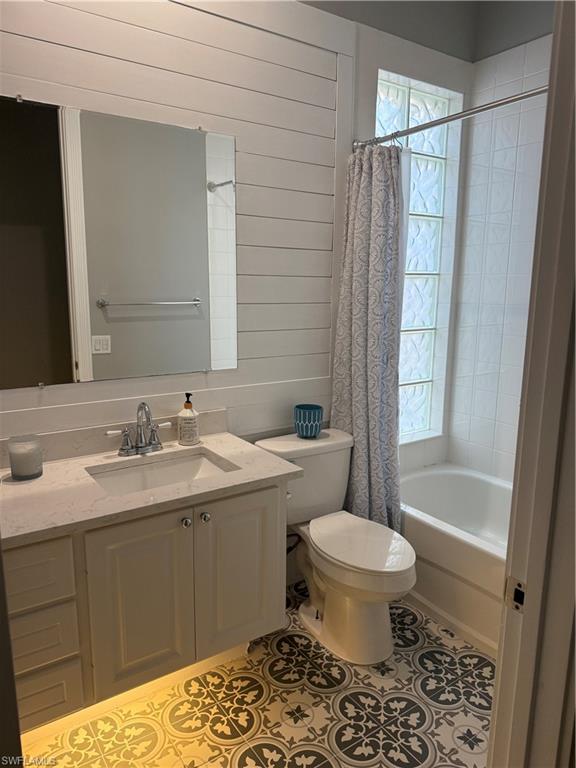 7549 Garibaldi Court Naples, FL 34114 - Photo 18 of 46 Full bathroom with wood walls, vanity, shower / bath combo, healthy amount of natural light, and light tile patterned floors