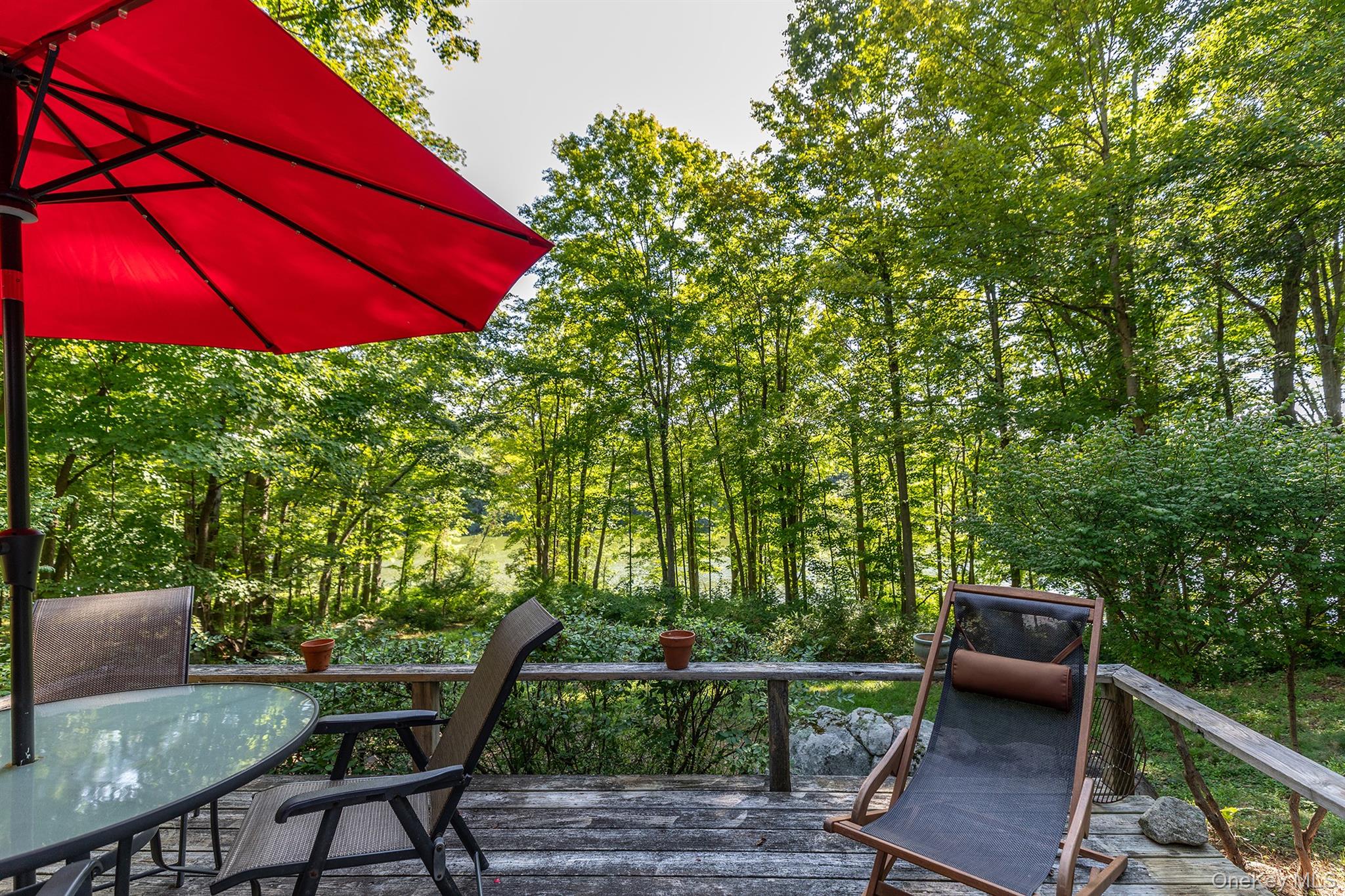 Undisclosed Address Brewster, NY 10509 - Photo 25 of 39 a view of a roof deck with table and chairs under an umbrella