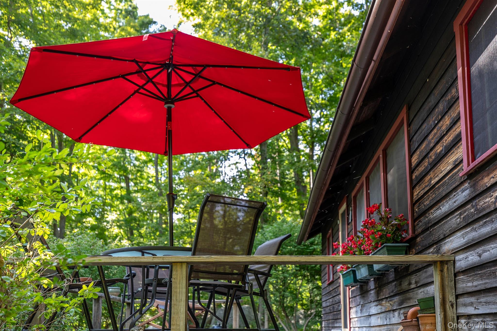 Undisclosed Address Brewster, NY 10509 - Photo 36 of 39 a view of a balcony with furniture and red umbrella
