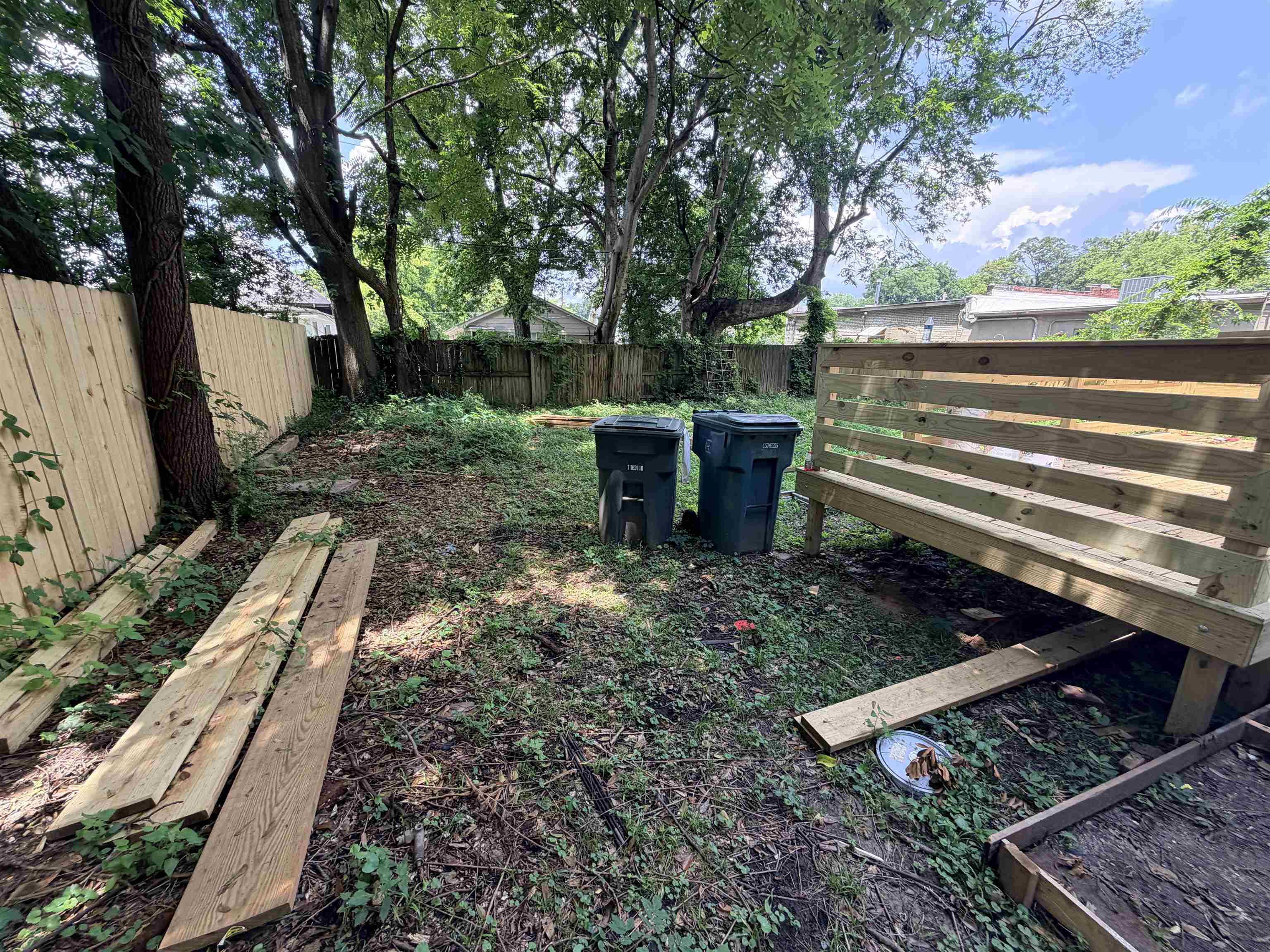 961 Meda Street Memphis, TN 38104 - Photo 27 of 27 Backyard area featuring a new wood privacy fence, mature trees, and a recently constructed wood bench