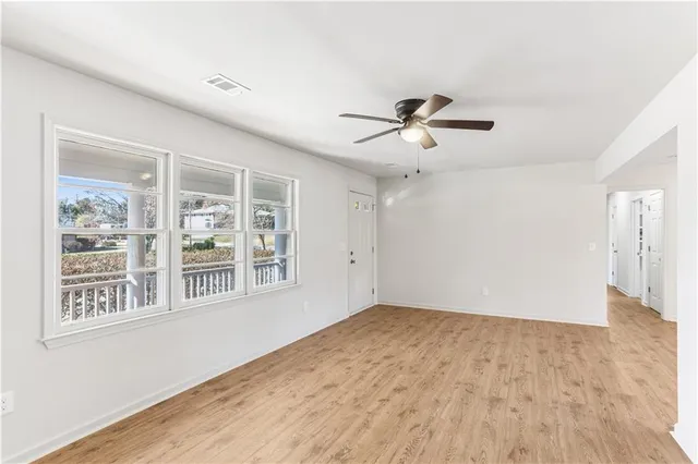 a view of a big room with wooden floor and a chandelier fan