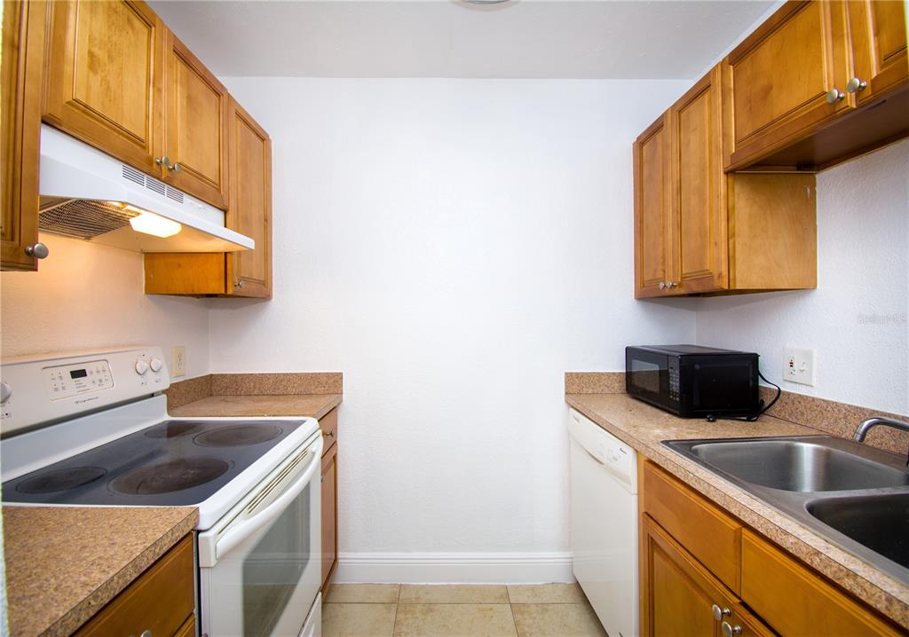 13830 Orange Sunset Drive, Unit 202 Tampa, FL 33618 - Photo 12 of 34 a kitchen with a sink a stove and a microwave oven