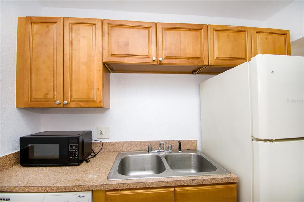 13830 Orange Sunset Drive, Unit 202 Tampa, FL 33618 - Photo 16 of 34 a kitchen with a sink cabinets and a refrigerator