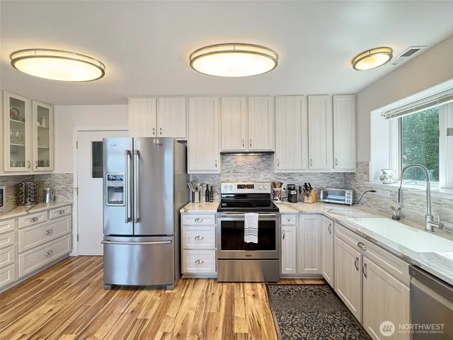 a kitchen with a sink a refrigerator and cabinets