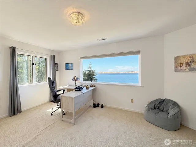 a view of a workspace with furniture and a window