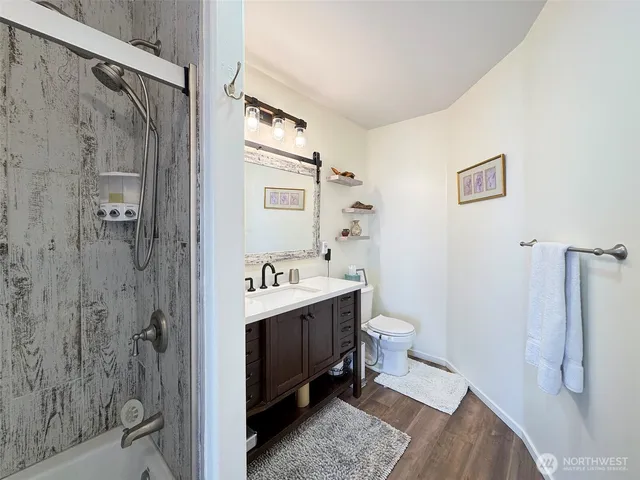 a bathroom with a sink a toilet and shower