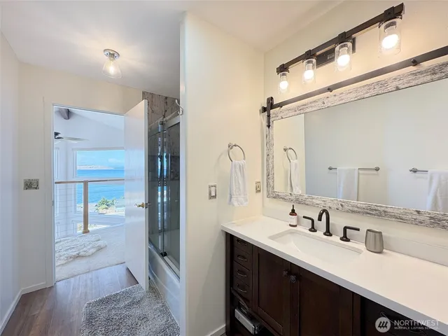 a spacious bathroom with a double vanity sink a mirror and shower