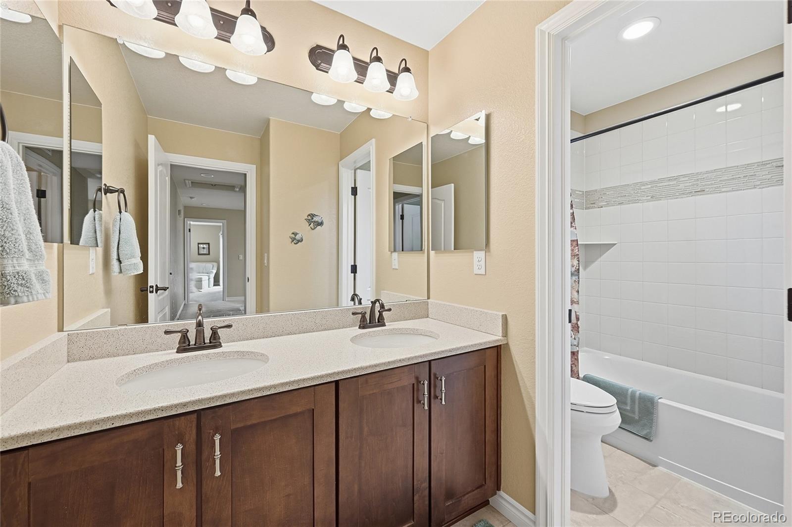 9500 Pendio Court Highlands Ranch, CO 80126 - Photo 13 of 15 a bathroom with a sink a toilet and a large mirror