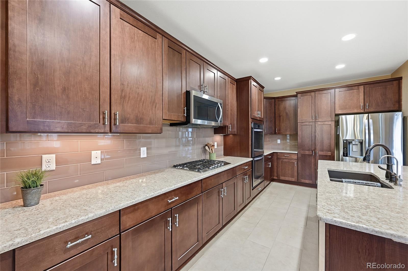9500 Pendio Court Highlands Ranch, CO 80126 - Photo 5 of 15 a kitchen with stainless steel appliances granite countertop a sink stove and refrigerator