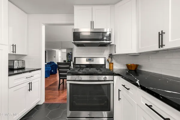 a kitchen with stainless steel appliances granite countertop a stove and a microwave