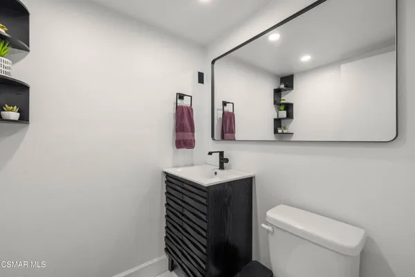 a bathroom with a sink a toilet and mirror