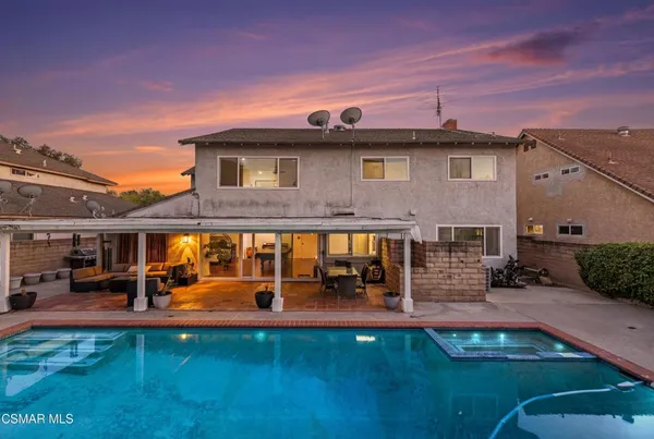 a front view of a house with swimming pool having outdoor seating