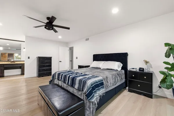 a spacious bedroom with a bed and ceiling fan