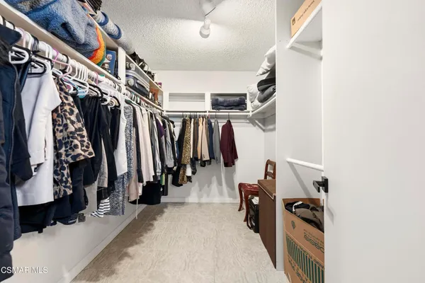 a view of walk in closet with clothes and shoes