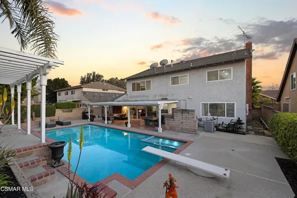 a view of a house with pool and chairs