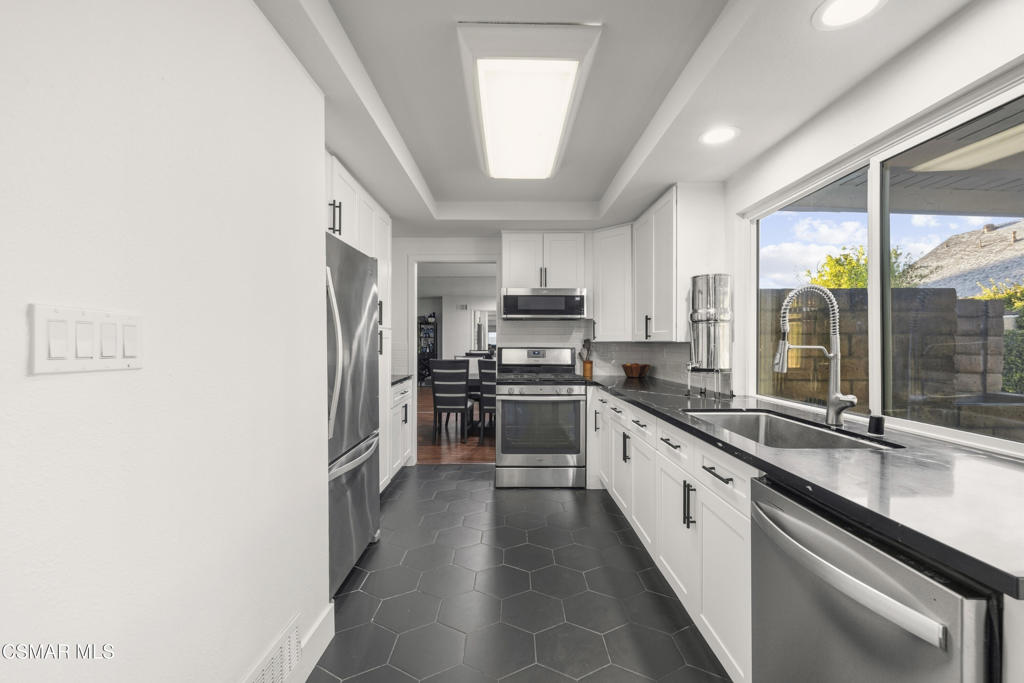 2371 Larch Street Simi Valley, CA 93065 - Photo 4 of 40 a large kitchen with granite countertop a large window and stainless steel appliances