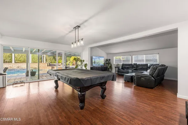 a living room with furniture a lamp wooden floor and a large window