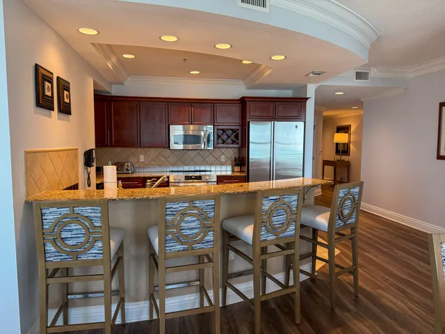 a kitchen with a table chairs refrigerator and microwave