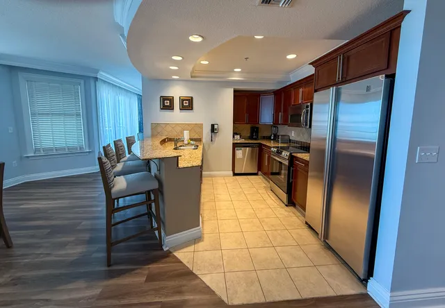 a kitchen with stainless steel appliances granite countertop a refrigerator and a stove top oven