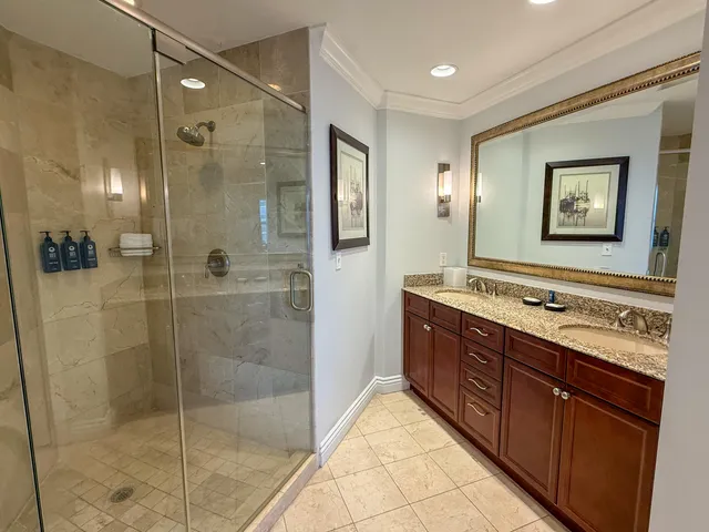 a bathroom with a double vanity sink mirror and shower