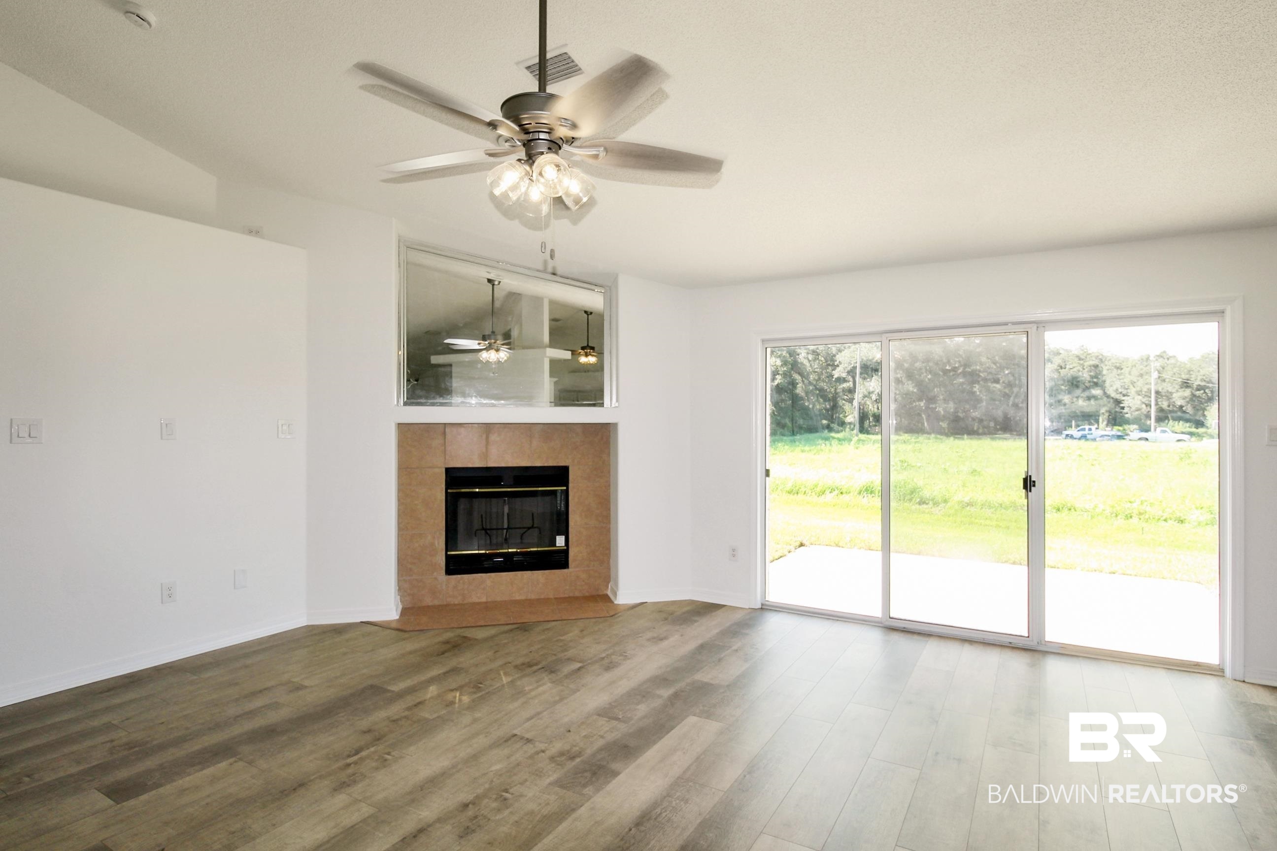 14750 Pawnee Court Foley, AL 36535 - Photo 14 of 34 Unfurnished living room featuring a ceiling fan, wood finished floors, and a tile fireplace