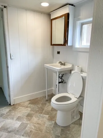a bathroom with a toilet a sink and a mirror