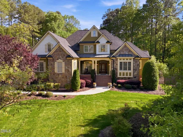 a front view of a house with a yard and trees
